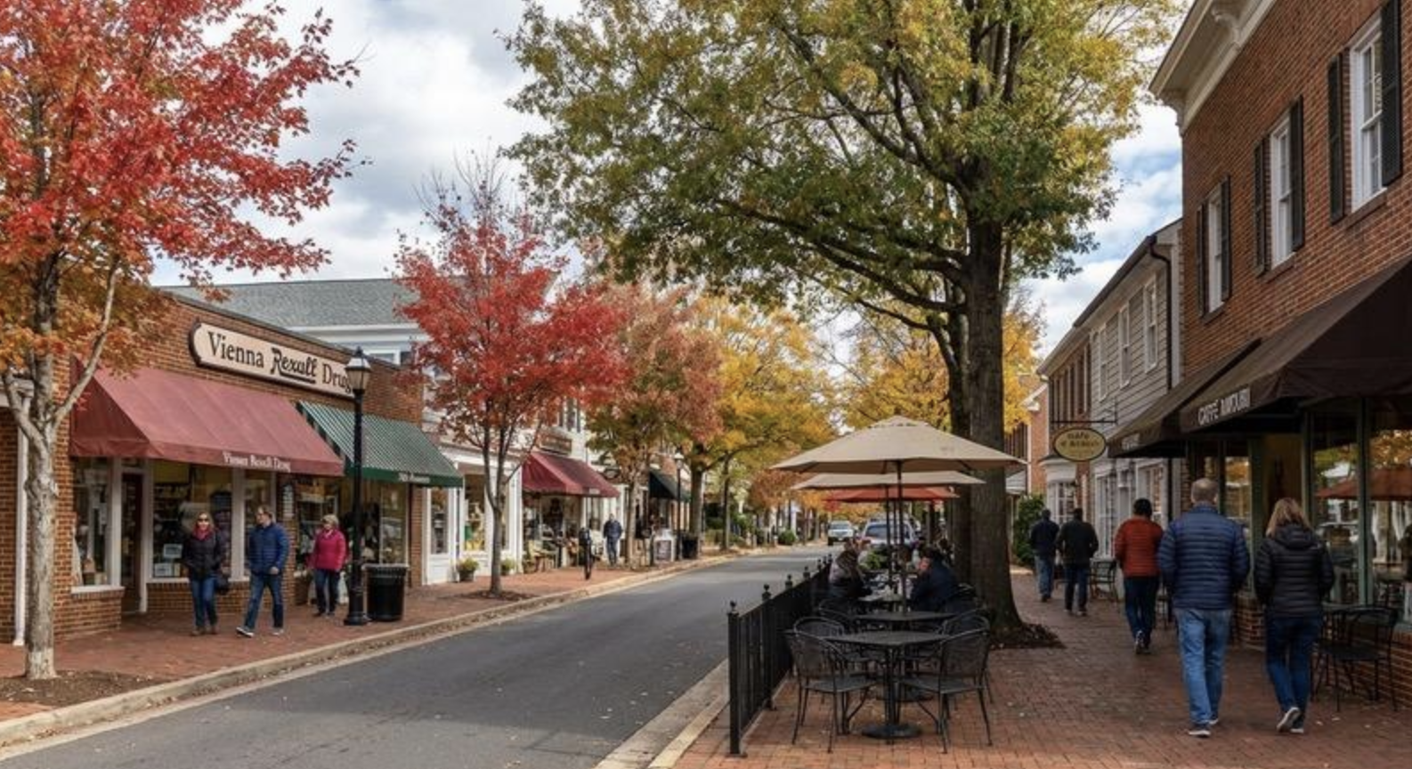 Shops, outdoor seating, and autumn trees along a Vienna street